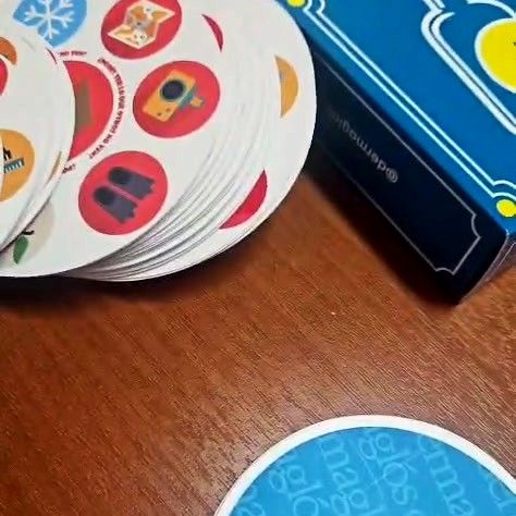 Cartas redondas abiertas en abanico con símbolos ilustrados a todo color junto a su caja