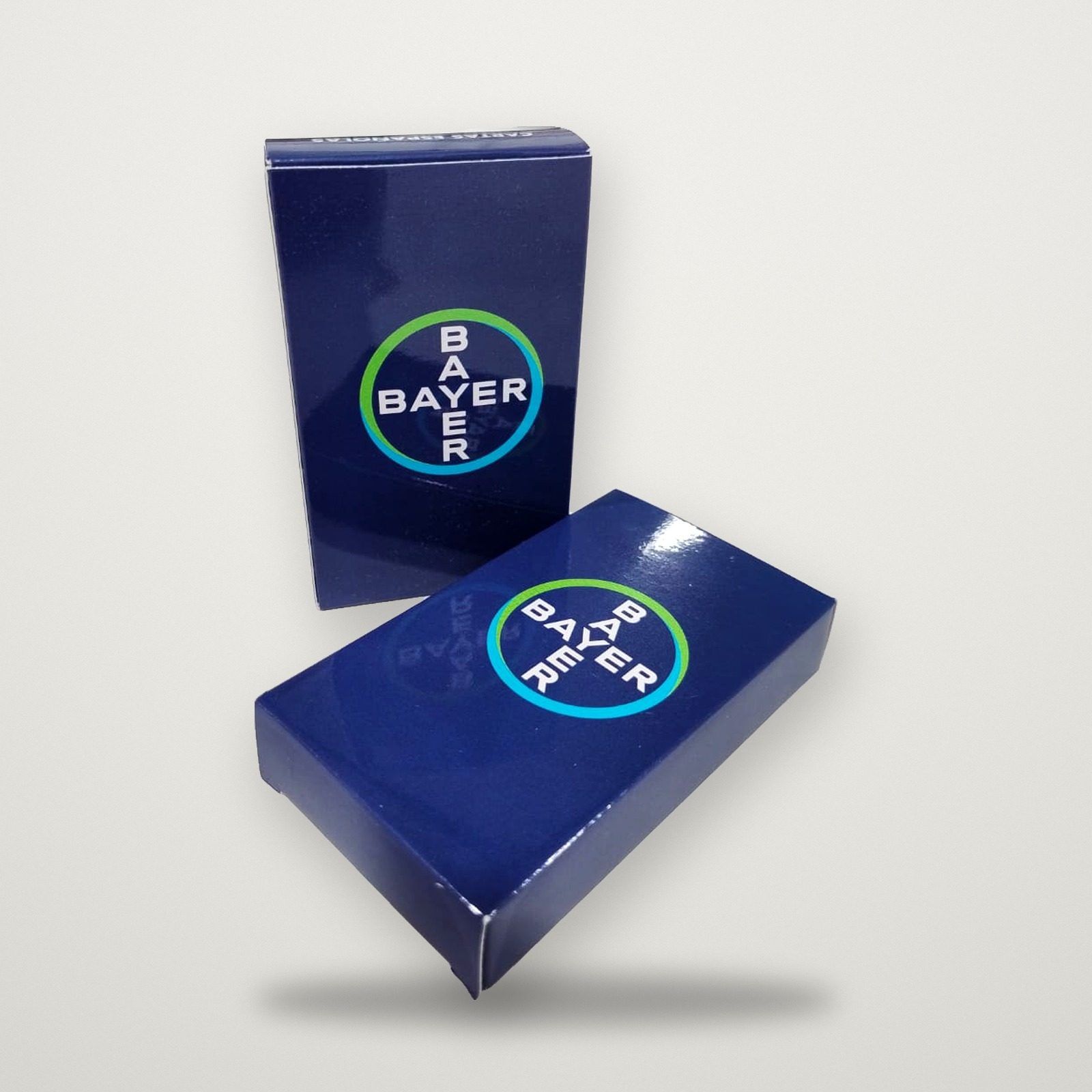 Mazos de cartas con estuche azul y logo de Bayer
